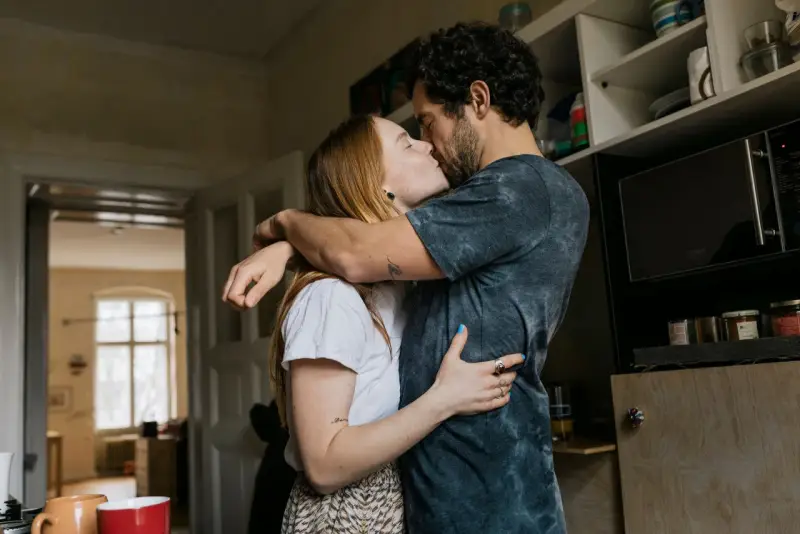 Pareja besándose apasionadamente, sus abrazos y miradas son claras señales no verbales de su amor.